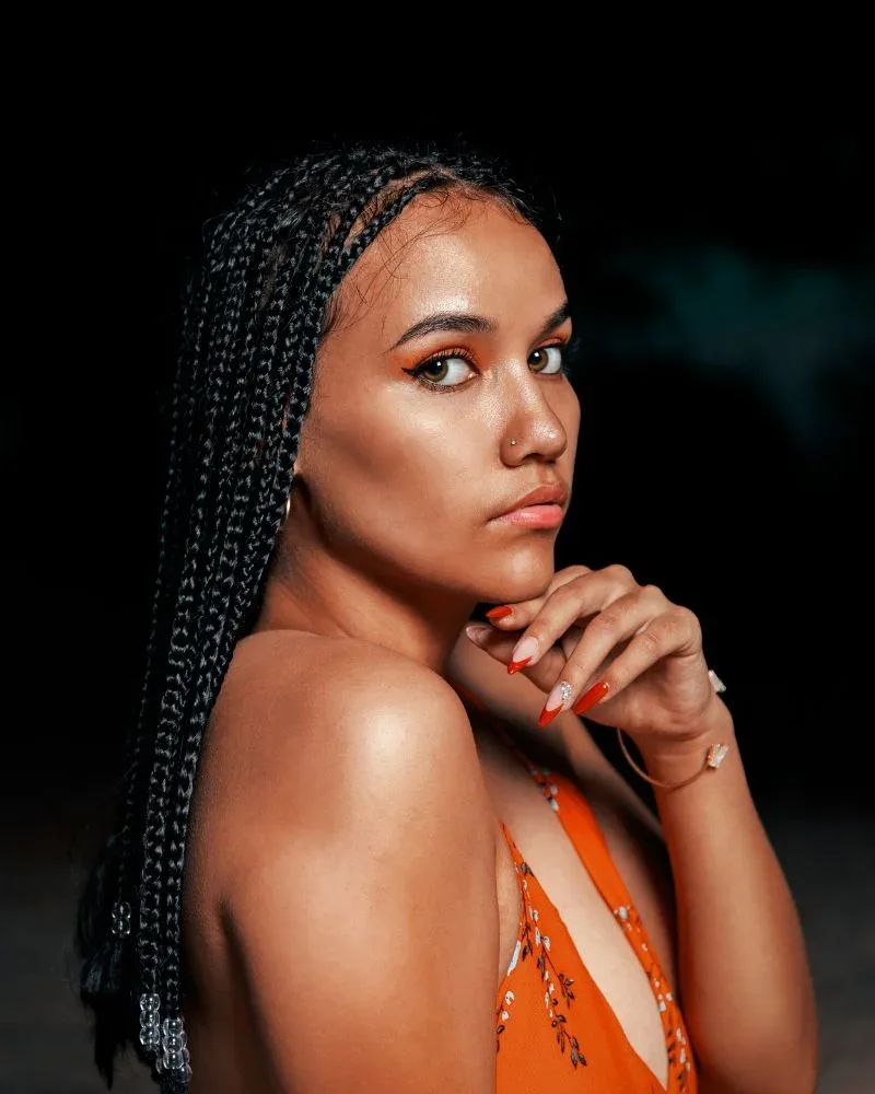 Woman wearing black braids with a visible hairline.