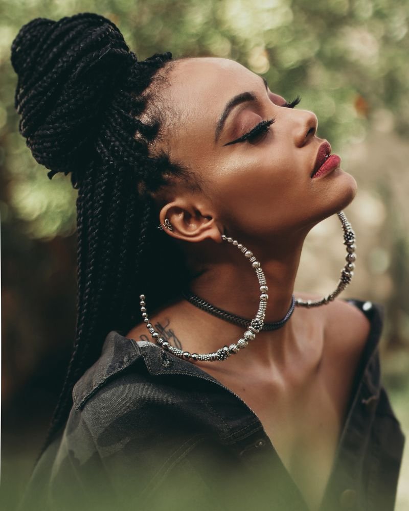 Woman wearing long braids in a bun.