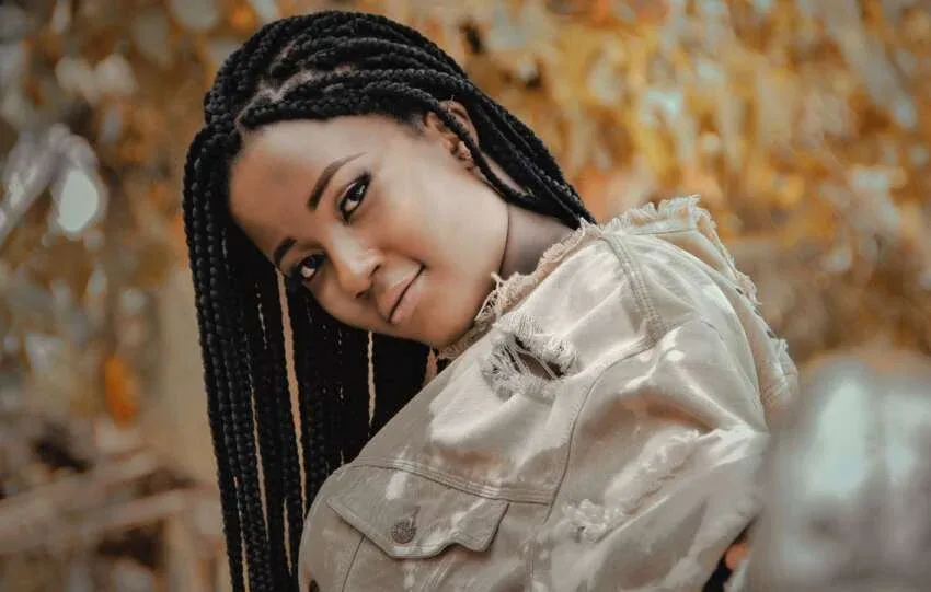 Black woman wearing medium box braids outdoors.