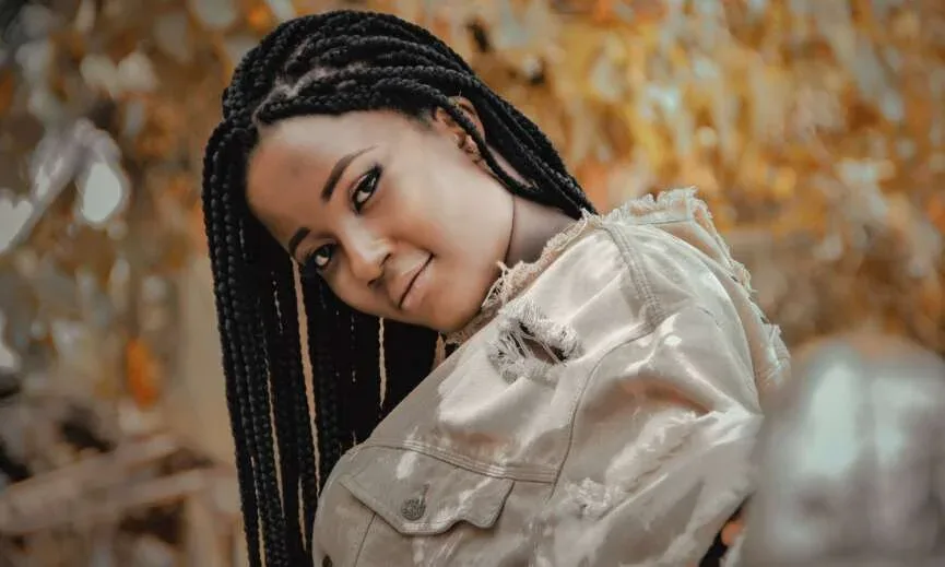 Black woman wearing medium box braids outdoors.