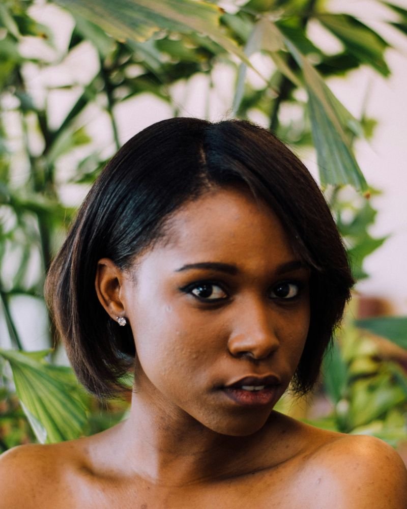 Woman with a smooth silk press showing healthy, straight natural hair.