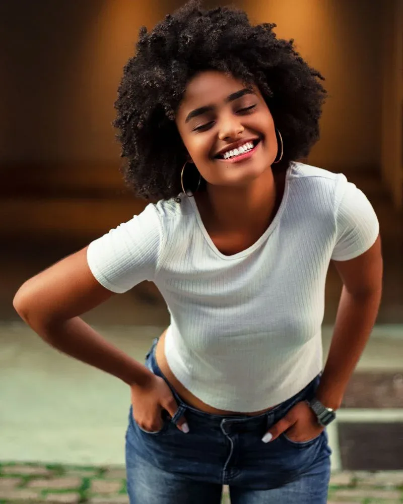 Smiling woman wearing her natural coily hair