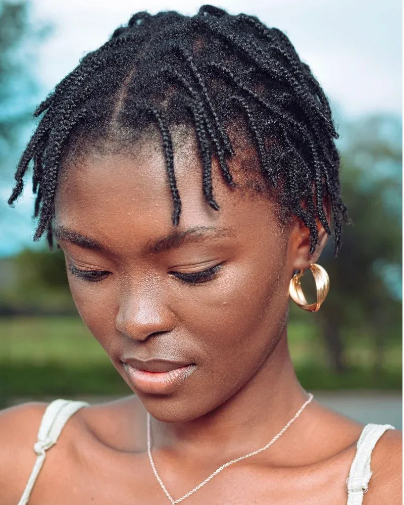 Black woman wearing mini braids created with her natural hair.
