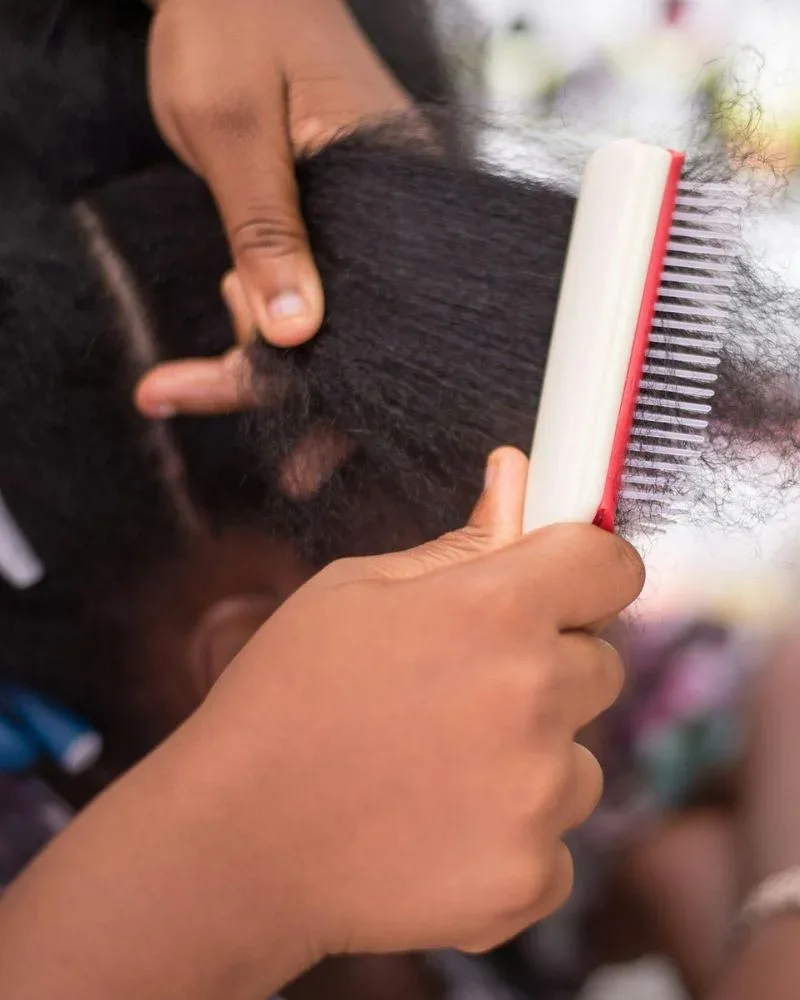 comb pulling through natural hair showing tension and mechanical stress
