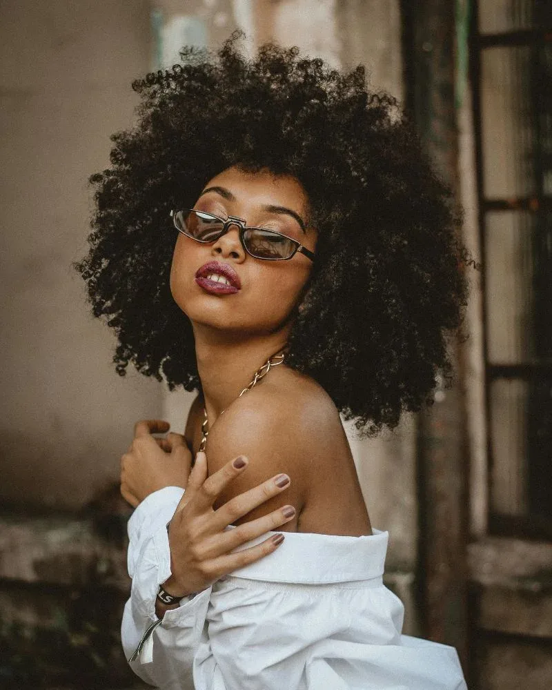 Woman with defined 4A natural hair curls and visible coil pattern.