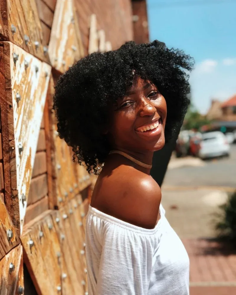 Woman with fluffy 4B natural hair showing a dense zig-zag texture.