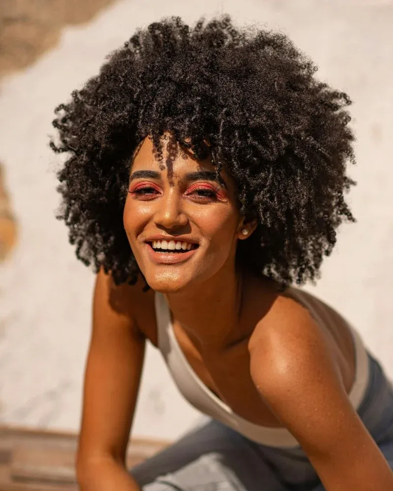 Woman with fluffy 4B natural hair showing a dense zig-zag texture.