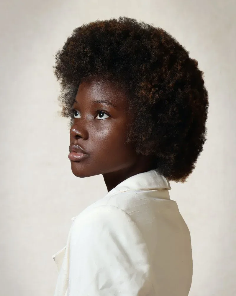 Woman with tightly coiled 4C natural hair with high shrinkage and volume.