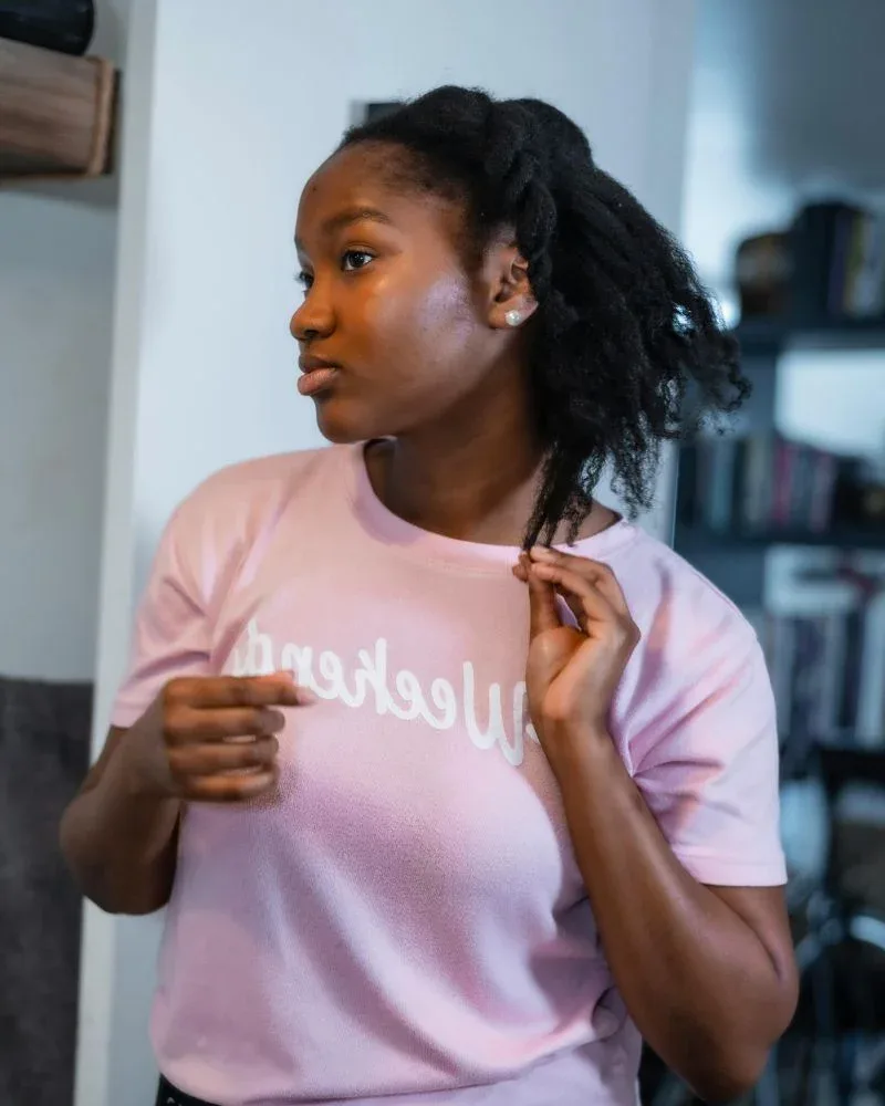 Woman examining the ends of her natural hair during a hair dusting routine