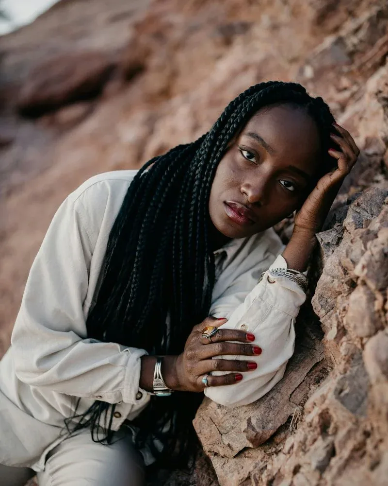 Woman wearing long braids as a low manipulation protective style
