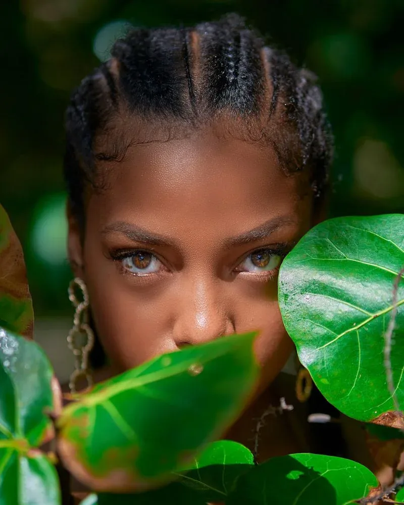 Close-up of a woman with cornrows wearing a low manipulation protective hairstyle for fine natural hair