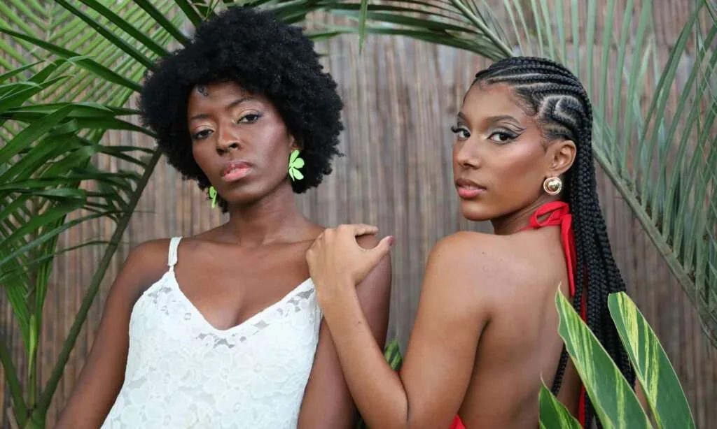 Woman with natural afro beside woman wearing cornrows, showing low-manipulation hairstyles for a 4C hair routine