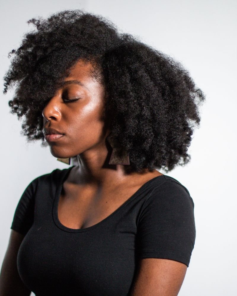 Woman with healthy natural afro hair wearing a black top