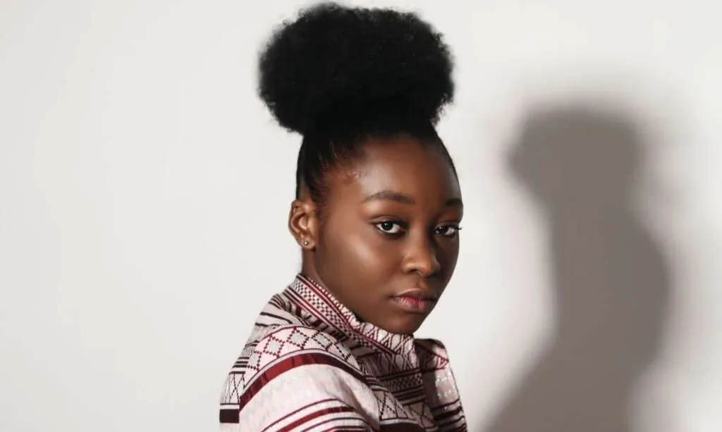 Woman with natural afro puff hairstyle wearing a patterned top