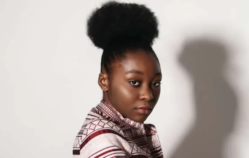 Woman with natural afro puff hairstyle wearing a patterned top
